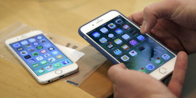A customer sets up his new iPhone 7 Plus, right, as he switches from the iPhone 6 at the Apple Store on Michigan Avenue during the release of the Apple iPhone 7 and the latest Apple Watches, Friday, Sept. 16, 2016, in Chicago. (AP Photo/Kiichiro Sato)