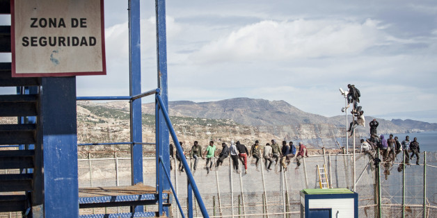 African migrants sit on top of a border fence between Morocco and Spain's north African enclave of Melilla during their latest attempt to cross into Spanish territory, April 3, 2014. Spain has more than doubled the strength of security forces at Melilla, after about 500 people stormed its fences in the biggest border rush for years earlier this month. Immigrants from all over Africa regularly dare the razor-wire fences of Spanish enclaves Ceuta and Melilla, which are surrounded by Moroccan terri