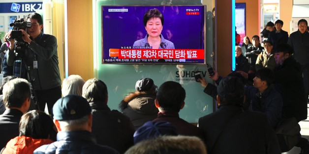 People watch a television news live showing South Korean President Park Geun-Hye making a speech, at a railway station in Seoul on November 29, 2016.South Korea's scandal-hit President Park Geun-Hye said on November 29 she was willing to leave office before the end of her official term early 2018 and would let parliament decide on her fate. / AFP / JUNG Yeon-Je (Photo credit should read JUNG YEON-JE/AFP/Getty Images)