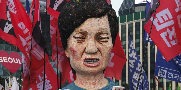 Protesters carry an effigy of South Korea's President Park Geun-Hye during an anti-government rally demanding the resignation of the president in central Seoul on November 30, 2016.An impeachment vote against South Korea's scandal-hit president will be postponed by at least a week, lawmakers said on November 30, after Park Geun-Hye announced she was willing to stand down early. / AFP / JUNG Yeon-Je (Photo credit should read JUNG YEON-JE/AFP/Getty Images)