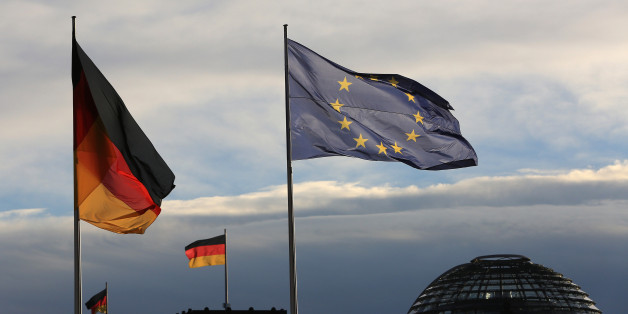 The German national flag flies beside a European Union (EU) flag outside the Chancellery in Berlin, Germany, on Friday, Nov. 18, 2016. Germany's Chancellor Merkel said she's ready to work with U.S. President-elect Donald Trump and won praise for her leadership from U.S. President Barack Obama, who suggested Germans would do well to re-elect her next year. Photographer: Krisztian Bocsi/Bloomberg via Getty Images