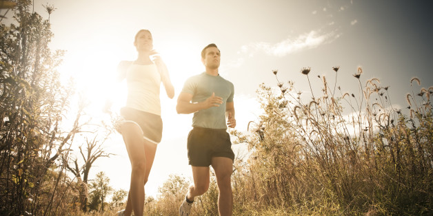 Caucasian couple running together on path