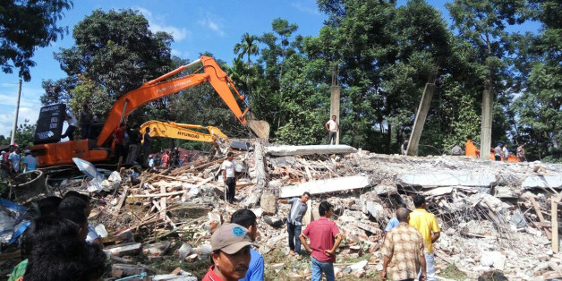 Rescuers use heavy machine to search for survivors under the rubble of a collapsed building after an earthquake in Pidie Jaya, Aceh province, Indonesia, Wednesday, Dec. 7, 2016. A strong undersea earthquake rocked Indonesia's Aceh province early on Wednesday, killing a number of people and causing dozens of buildings to collapse. (AP Photo/Heri Juanda)