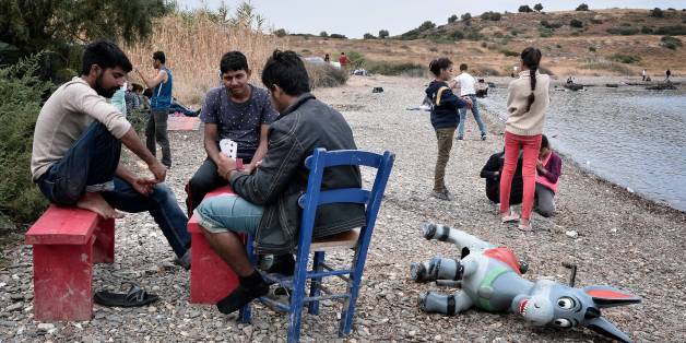 Refugees play cards on the beach at an unofficial migrant camp, run by activists on the island of Lesbos on September 22, 2016. / AFP / LOUISA GOULIAMAKI (Photo credit should read LOUISA GOULIAMAKI/AFP/Getty Images)