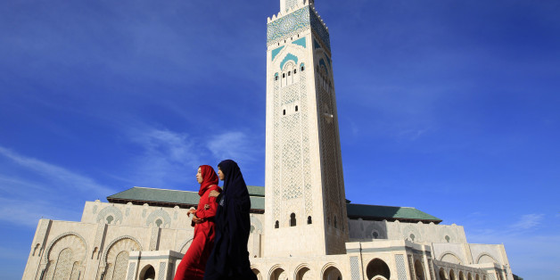 Moroccan women walk past the Hassan II mosque in Casablanca February 24, 2011. The minaret of the mosque is the highest in the world, standing at 210 metres (689 feet). REUTERS/Pascal Rossignol (MOROCCO - Tags: RELIGION IMAGES OF THE DAY)