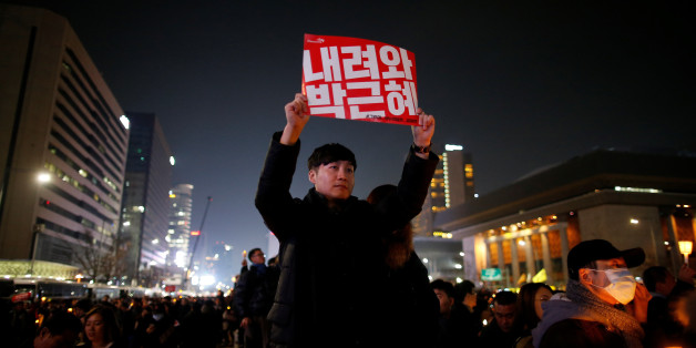 A man holds up a sign that reads "Step down Park Geun-hye" during a protest calling for South Korean President Park Geun-hye to step down in central Seoul, South Korea, December 3, 2016. REUTERS/Kim Hong-Ji