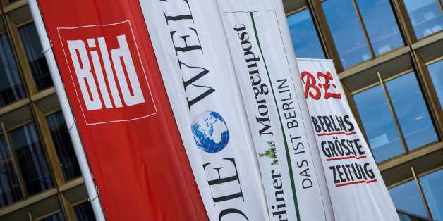 Flags with the logos of the main newspapers of German publisher Axel Springer fly outside its headquarters in Berlin August 7, 2013. REUTERS/Thomas Peter/File Photo GLOBAL BUSINESS WEEK AHEAD PACKAGE - SEARCH 'BUSINESS WEEK AHEAD MAY 9' FOR ALL IMAGES