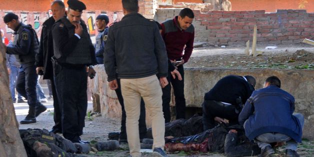 EDITORS NOTE: Graphic content / Egyptians check bodies at the site of a bomb attack next to a police checkpoint in the western Talibiya district of the capital Cairo on December 9, 2016. / AFP / STRINGER (Photo credit should read STRINGER/AFP/Getty Images)