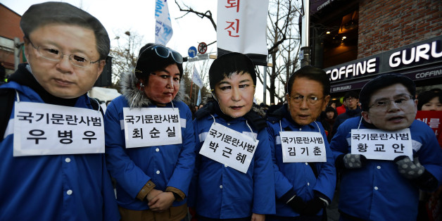 SEOUL, SOUTH KOREA - DECEMBER 10: Protesters wearing masks of South Korea's President Park Geun-Hye (R) and the president's long-time friend Choi Soon-Sil (L) walk during a rally against South Korean President Park Geun-Hye on December 10, 2016 in Seoul, South Korea. The South Korean National Assembly voted yesterday for an impeachment motion at its plenary session, which will set up the rare impeachment trial for President Park over the accusation of corruption involving Park and her long time
