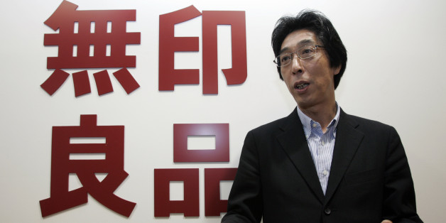 Japan's Ryohin Keikaku Co President Masaaki Kanai speaks during an interview next to the company's logo for its Muji retail chain, in Tokyo November 17, 2008. Ryohin Keikaku, which operates Muji stores, would find it hard to meet its full-year profit forecast given rapidly deteriorating consumer spending, Kanai said. REUTERS/Yuriko Nakao (JAPAN)