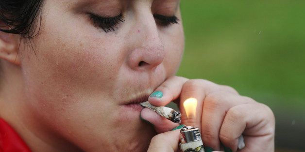 A woman lights a joint as a group of cannabis advocates smoke marijuana and march down Broad Street toward the Wells Fargo Center on the final day of the Democratic National Convention in Philadelphia, Pennsylvania, U.S., July 28, 2016. REUTERS/Dominick Reuter