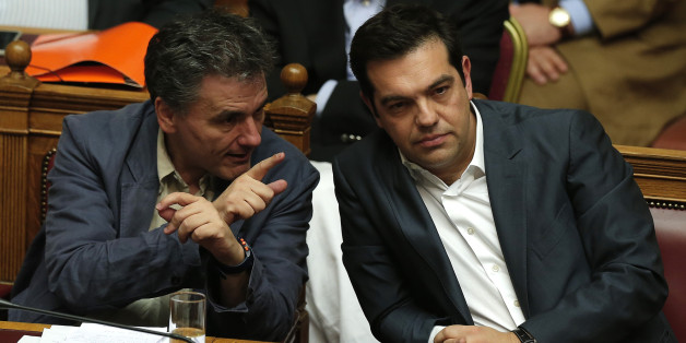 Greek Prime Minister Alexis Tsipras (R) sits next to Finance Minister Euclid Tsakalotos (L) as he attends a parliamentary session in Athens, Greece July 15, 2015. Prime Minister Alexis Tsipras battled to win lawmakers' approval on Wednesday for a bailout deal to keep Greece in the euro, while the country's creditors, pressed by the IMF to provide massive debt relief, struggled to agree a financial lifeline. REUTERS/Alkis Konstantinidis