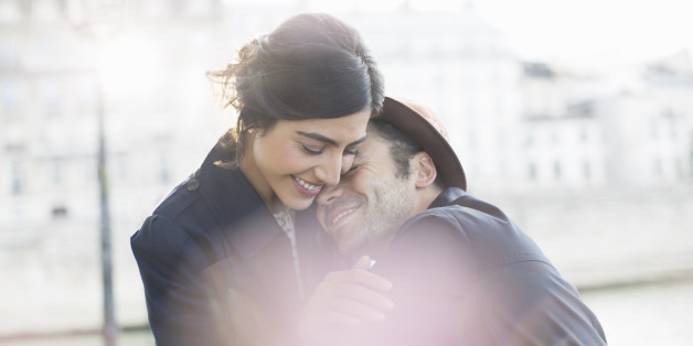 Couple hugging along Seine River, Paris, France