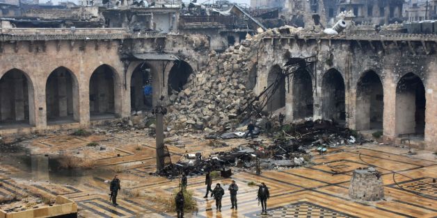 TOPSHOT - A general view shows Syrian pro-government forces walking in the ancient Umayyad mosque in the old city of Aleppo on December 13, 2016, after they captured the area.After weeks of heavy fighting, regime forces were poised to take full control of Aleppo, dealing the biggest blow to Syria's rebellion in more than five years of civil war. / AFP / George OURFALIAN (Photo credit should read GEORGE OURFALIAN/AFP/Getty Images)