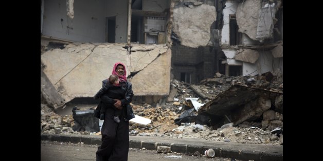 Syrians leave a rebel-held area of Aleppo towards the government-held side on December 13, 2016 during an operation by Syrian government forces to retake the embattled city.UN chief Ban Ki-moon expressed alarm over reports of atrocities against civilians Monday, as the battle for Aleppo entered its final phase with Syrian government forces on the verge of retaking rebel-held areas of the city. / AFP / KARAM AL-MASRI (Photo credit should read KARAM AL-MASRI/AFP/Getty Images)