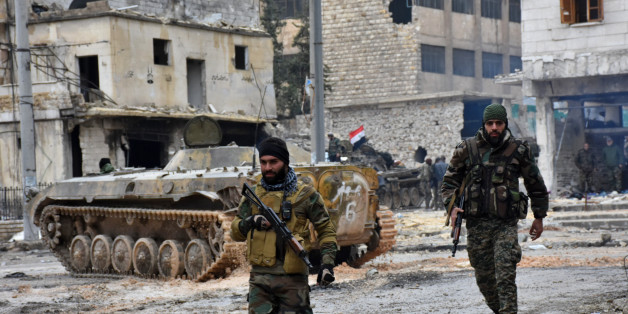 Syrian pro-government forces patrol the northern city of Aleppo on December 14, 2016. Shelling and air strikes sent terrified residents running through the streets of Aleppo as a deal to evacuate rebel districts of the city was in danger of falling apart. / AFP / George OURFALIAN (Photo credit should read GEORGE OURFALIAN/AFP/Getty Images)