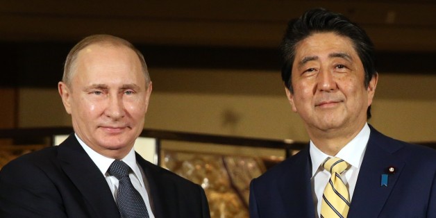 JAPAN, NAGATO - DECEMBER 15: (RUSSIA OUT) Russian President Vladimir Putin (L) shakes hands with Japanese Prime Minister Shinzo Abe (R) during the official reception ceremony on December 15, 2016 in Nagato, Japan. The Russian president is on a two-days visit to Japan. (Photo by Mikhail Svetlov/Getty Images)
