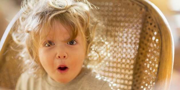 Caucasian baby boy gasping in wicker chair