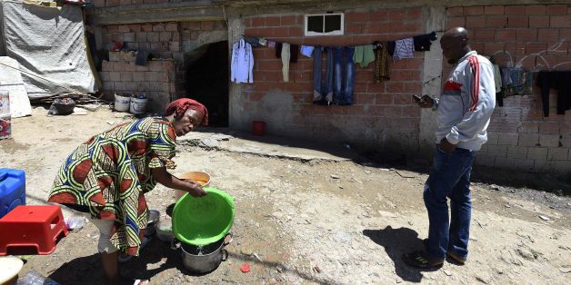 A Sub-Saharan woman does some washing-up at the bottom of a makeshift building, where she lives with other fellow migrants in impoverished conditions, on May 29, 2016, in the capital Algiers. In the past, Algeria was a land of emigration, millions of its citizens exiled to France, but in recent years it has become a destination country for many West Africans. Nigerians, Malians, Cameroonians, brave the horrors of the Sahara to find refuge in the largest country in Africa, as the crossing to Eur