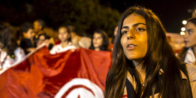 A woman attends a protest to condemn an attack by a gunman at the beach of the Imperial Marhabada hotel in Sousse, Tunisia, June 27, 2015. Tour companies were evacuating thousands of foreign holidaymakers from Tunisia on Saturday, a day after a gunman killed 39 people as they lounged at the beach in an attack claimed by Islamic State. Tunisia's Prime Minister Habib Essid said most of the dead were British, and its health ministry said eight Britons, a German, a Belgian and an Irish citizen were