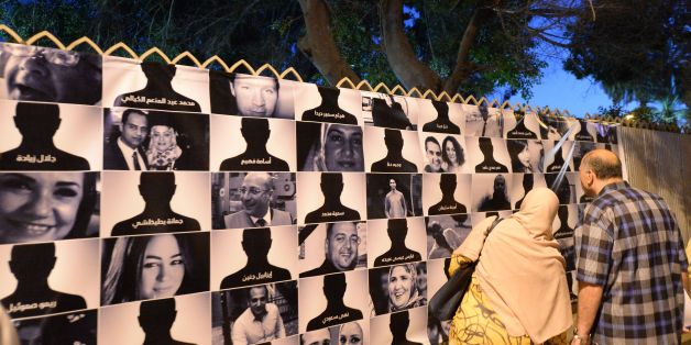 Egyptians look at posters of the 66 victims of the EgyptAir MS804 flight that crashed in the Mediterranean Sea, as they take part in a march near the Cairo Opera House in the Egyptian capital in honour of them on May 26, 2016.Investigators are still searching for the Airbus A320's two black boxes on the seabed as they seek answers as to why the aircraft came down early on May 19, with 66 people on board. / AFP / KHALED DESOUKI (Photo credit should read KHALED DESOUKI/AFP/Getty Images)
