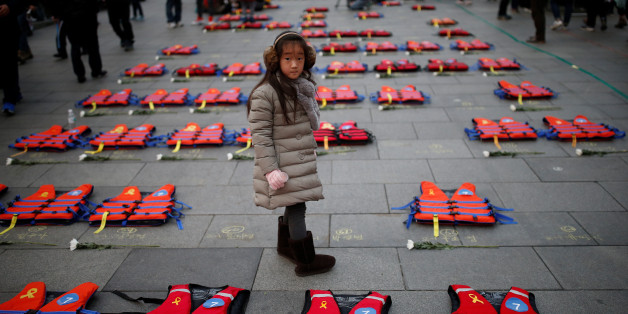 A girl stands between life vests symbolising the 304 victims of sunken ferry Sewol during a protest demanding South Korean President Park Geun-hye's resignation in Seoul, South Korea December 17, 2016. REUTERS/Kim Hong-Ji