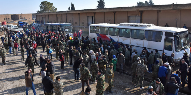 Syrians who were evacuated from Fuaa and Kafraya,two Shiite villages under rebel-siege on the northern outskirts of Idlib are welcomed by pro-government forces as they arrive in Jibrin on the eastern outskirts of Aleppo on December 19, 2016. / AFP / George OURFALIAN (Photo credit should read GEORGE OURFALIAN/AFP/Getty Images)