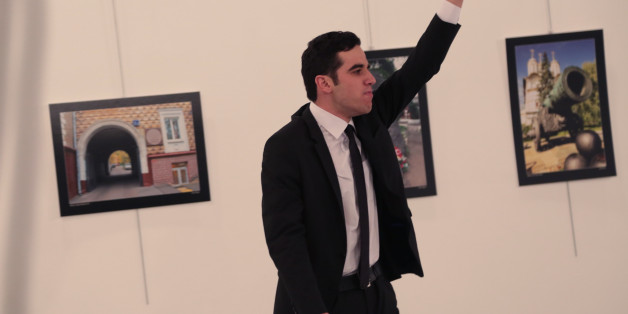 An unnamed gunman gestures after shooting the Russian Ambassador to Turkey, Andrei Karlov, at a photo gallery in Ankara, Turkey, Monday, Dec. 19, 2016. A gunman opened fire on Russia's ambassador to Turkey at a photo exhibition on Monday. The Russian foreign ministry spokeswoman said he was hospitalized with a gunshot wound. (AP Photo/Burhan Ozbilici)