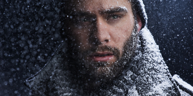 Cropped shot of a serious young man covered in snow in the dark