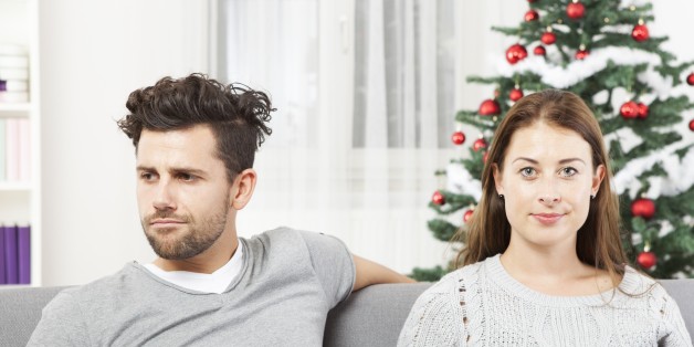 young modern couple is irritated of christmas with christmas tree in background