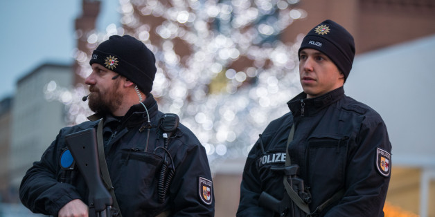 Armed policemen stand at the christmas market in Schwerin, northern Germany, on December 20, 2016 one day after a truck crashed into a Christmas market in Berlin.Twelve people were killed and almost 50 wounded, 18 seriously, when the lorry tore through the crowd on December 19, 2016, smashing wooden stalls and crushing victims, in scenes reminiscent of July's deadly attack in the French Riviera city of Nice. / AFP / dpa / Jens Büttner / Germany OUT (Photo credit should read JENS BUTTNE