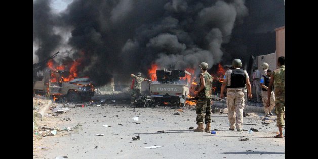 Fighters from the pro-government forces loyal to Libya's Government of National Unity (GNA) look at some of their vehicles burning after a suicide bomber of the Islamic State group (IS) detonated his explosives close to a group of soldiers on August 16, 2016 in an area of central Sirte, known as District Two.
Libyan pro-government forces said they seized control of District Two as they tried to flush out the last Islamic State group fighters in the coastal city of Sirte. Dozens of US air strikes this month have helped to weaken IS's hold on Sirte, which the jihadists seized last year and established as their main base outside Syria and Iraq. / AFP / STR (Photo credit should read STR/AFP/Getty Images)