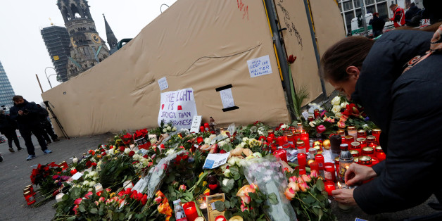 Flowers and posters are placed at the scene where a truck ploughed into a crowded Christmas market in the German capital last night in Berlin, Germany, December 20, 2016 REUTERS/Fabrizio Bensch