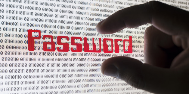 A male hand grabbing the word 'PASSWORD' on a computer screen with binary code.