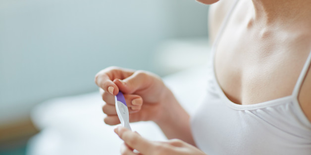 Young woman with pregnancy test in hands