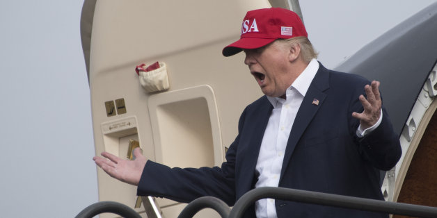 US President-elect Donald Trump reacts as he walks off his plane as members of the Azalea Trail Maids wait for his arrival in Mobile, Alabama, for a 'Thank You Tour 2016' rally on December 17, 2016. / AFP / JIM WATSON (Photo credit should read JIM WATSON/AFP/Getty Images)