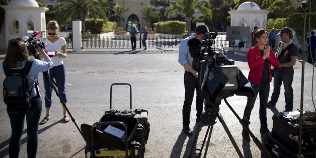 Journalists stand in front of the Riu Imperial Marhaba Hotel in Port el Kantaoui, on the outskirts of Sousse south of the capital Tunis, on June 27, 2015, in the aftermath of a shooting attack on the beach resort claimed by the Islamic State group. The IS group on June 27 claimed responsibility for the massacre in the seaside resort that killed nearly 40 people, most of them British tourists, in the worst attack in the country's recent history. AFP PHOTO / KENZO TRIBOUILLARD (Photo credit should read KENZO TRIBOUILLARD/AFP/Getty Images)