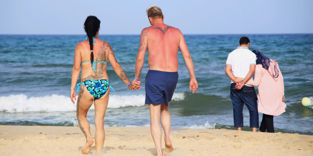 Tourists walk along on a beach in Hammamet, Tunisia, May 27, 2016. REUTERS/Zoubeir Souissi
