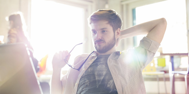 Casual businessman working at laptop in sunny office