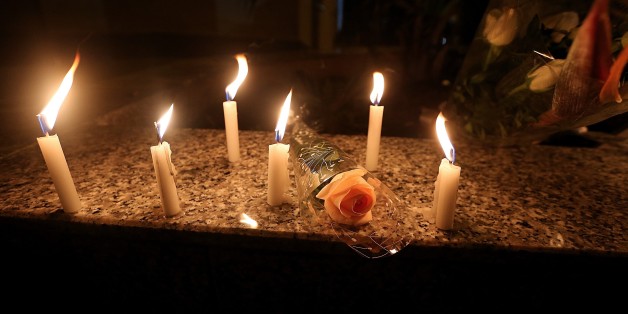 TUNIS, TUNISIA - DECEMBER 22 : A group of people light candles and lay flowers to pay tribute to the victims of an attack on a Christmas market in Berlin, in front of the German embassy in Tunis, Tunisia on December 22, 2016. (Photo by Yassine Gaidi/Anadolu Agency/Getty Images)