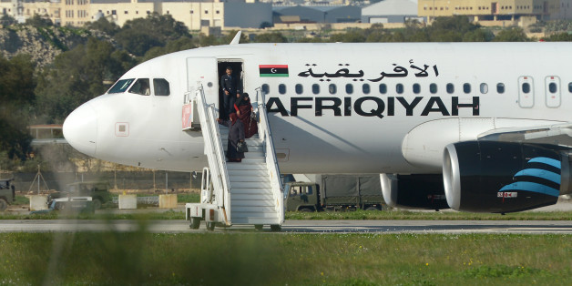 A picture taken on December 23, 2016 shows a group of hostages being released in Valletta, Malta, from the Afriqiyah Airways A320 after it was hijacked from Libya.A man who said he was armed with a grenade hijacked a Libyan plane which landed on Malta Friday with 118 people on board, Malta's prime minister and government sources on the Mediterranean island said. After more than an hour on the tarmac, the plane's door opened and a first group of women and children were seen descending a mobile st