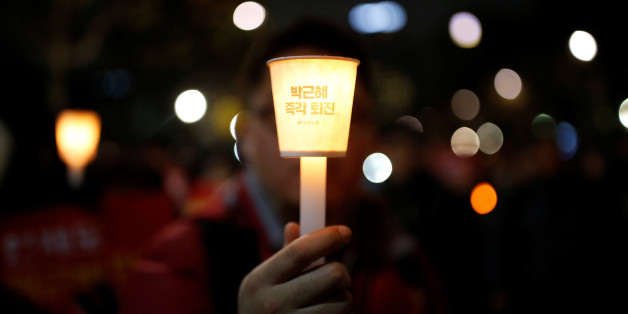 A man holds a candlelight bearing a message that reads "Step down Park Geun-hye immediately" near the constitutional court during a protest demanding South Korean President Park Geun-hye's resignation in Seoul, South Korea December 17, 2016. REUTERS/Kim Hong-Ji