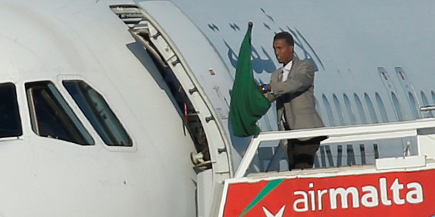 One of the hijackers of a Libyan Afriqiyah Airways Airbus A320 waves a Gaddafi-era Libyan flag at Malta Airport, December 23, 2016. REUTERS/Darrin Zammit-Lupi MALTA OUT. NO COMMERCIAL OR EDITORIAL SALES IN MALTA TPX IMAGES OF THE DAY