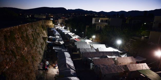 People sit by their tent in Souda camp on the island of Chios on September 29, 2016.
The EU said on September 28, 2016 it hoped to relocate 30,000 refugees from Greece by the end of next year, insisting it was making 'significant progress' on tackling the migrant crisis. A deal with Turkey to cut the flow of migrants to the Greek islands is also proving successful, said an assessment by the European Commission, the executive arm of the 28-nation bloc.
/ AFP / LOUISA GOULIAMAKI (Photo credit should read LOUISA GOULIAMAKI/AFP/Getty Images)