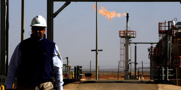 ALGERIA - DECEMBER 14: An employee walks in front of a gas flare at the In Salah Gas (ISG) Krechba Project, run by Sonatrach, British Petroleum (BP), and StatoilHydro, in the Sahara desert near In Salah, Algeria, on Sunday, Dec. 14, 2008. From produced gas, the carbon capture plant, the largest and first of its kind, removes annually the carbon dioxide emissions equivalent of 200,000 automobiles running 30,000 kilometers. The CO2 is then reinjected into a two-kilometer deep reservoir instead of