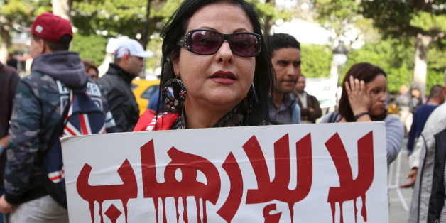 A woman holds a sign during a demonstration in solidarity with the victims of a series of deadly attacks in the French capital of Paris, in Tunis, Tunisia November 16, 2015. The sign reads, "No to terrorism." REUTERS/Zoubeir Souissi