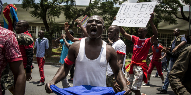 A Congolese protester holds a book of the DRC's constitution in defiance against the President of the Democratic Republic of the Congo, Joseph Kabila, at a protest demanding him to step down on December 20, 2016 in Pretoria.
The United Nations voiced alarm over a wave of arrests in the Democratic Republic of Congo, where tensions were running high after President Joseph Kabila's term in office expired. Tuesday marked the end of the second and constitutionally-mandated final term for the 45-year-old, who inherited the presidency after the 2001 assassination of his father. But he is now refusing to leave the job that he began without much fanfare.
/ AFP / John Wessels (Photo credit should read JOHN WESSELS/AFP/Getty Images)