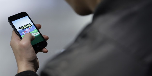 A man plays Nintendo Co.'s Super Mario Run mobile game on an Apple Inc. iPhone in this arranged photograph in Tokyo, Japan, on Thursday, Dec. 22, 2016. The game, released for Apple devices on Dec. 15, features the company's iconic plumber running across a scrolling landscape to rescue Princess Peach. Photographer: Kiyoshi Ota/Bloomberg via Getty Images
