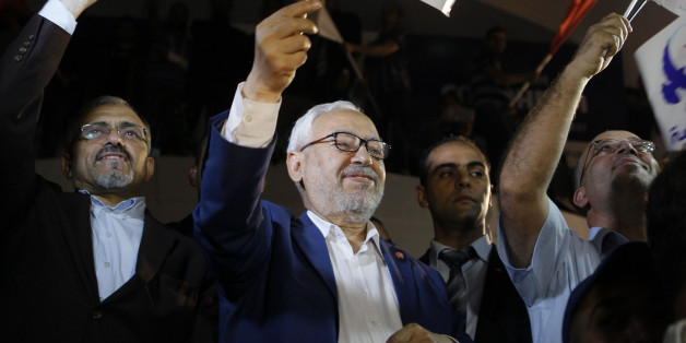 Rached Ghannouchi, leader of the Islamist party Ennahda, waves the party flag outside Ennahda's headquarters in Tunis October 27, 2014.Tunisia's Ennahda party, the first Islamist movement to secure power after the 2011 "Arab Spring" revolts, conceded defeat on Monday in elections that are set to make its main secular rival the strongest force in parliament. Official results from Sunday's elections - the second parliamentary vote since Tunisians set off uprisings across much of the Arab World by overthrowing autocrat Zine El-Abidine Ben Ali - were still to be announced. REUTERS/Zoubeir Souissi (TUNISIA - Tags: ELECTIONS POLITICS)