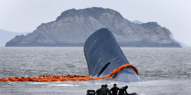A vessel involved in salvage operations passes near the upturned South Korean ferry "Sewol" in the sea off Jindo April 17, 2014. Rescuers were hammering on the upturned hull of a capsized South Korea ferry on Thursday hoping for a response from hundreds of people, mostly teenage schoolchildren, believed trapped after the vessel started sinking more than 24 hours previously. REUTERS/Kim Kyung-Hoon (SOUTH KOREA - Tags: DISASTER MARITIME TPX IMAGES OF THE DAY)